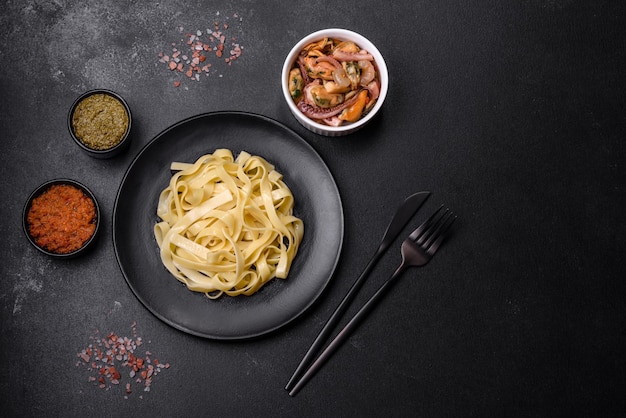 Deliciosa pasta fresca con salsa pesto y marisco en un plato negro