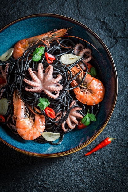 Deliciosa pasta negra marinera hecha de pulpo langostino tigre