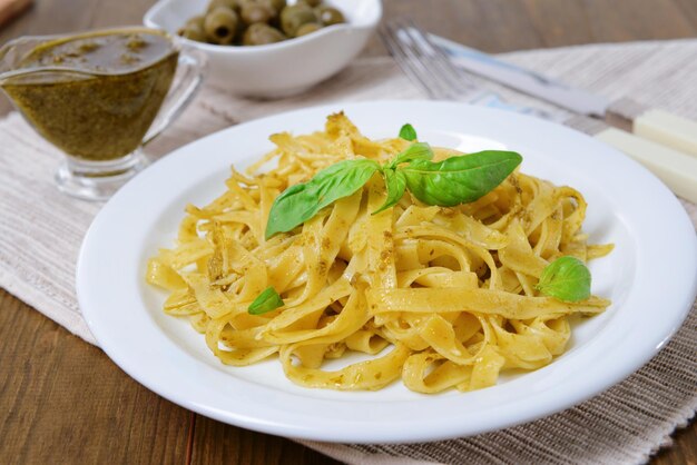 Deliciosa pasta con pesto en un plato en el primer plano de la mesa