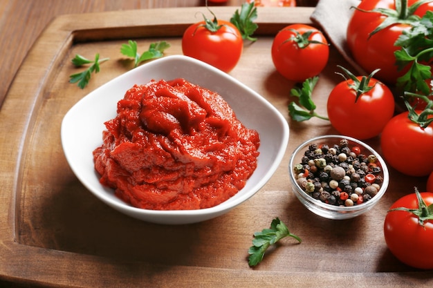 Deliciosa pasta de tomate en un tazón con ingredientes en el primer plano de la bandeja