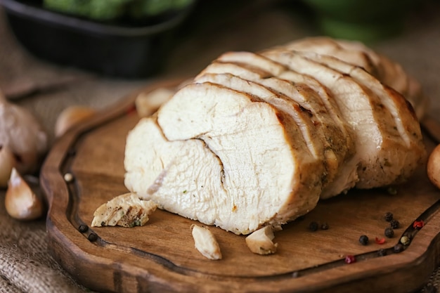 Deliciosa pechuga de pavo en rodajas sobre tabla de madera