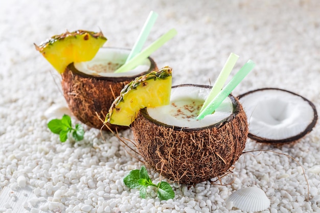 Deliciosa pinacolada em coco com abacaxi e folhas de hortelã
