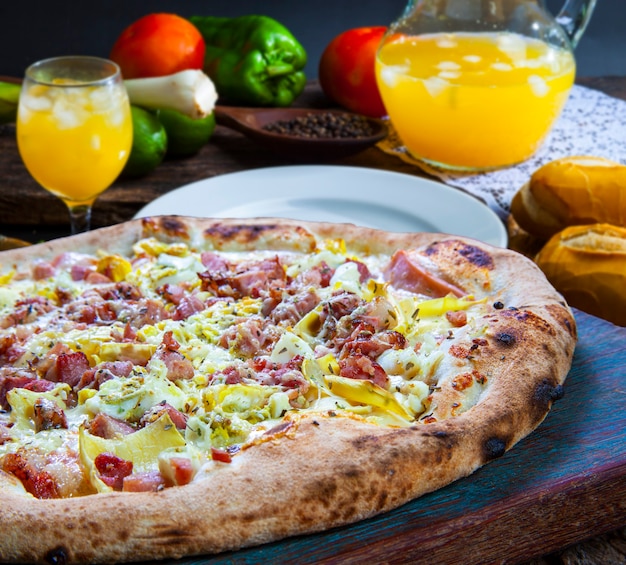 Deliciosa pizza asada con tocino y jugo de naranja