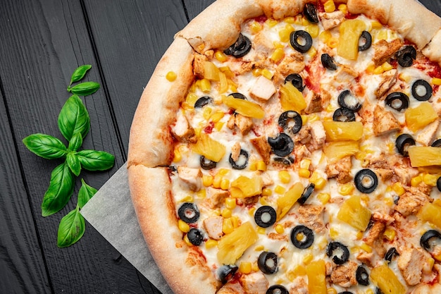 Deliciosa pizza con carne de pollo piña maíz y aceitunas