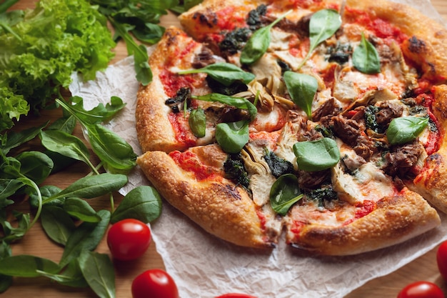 Deliciosa pizza com alcachofras e atum servida em mesa de madeira