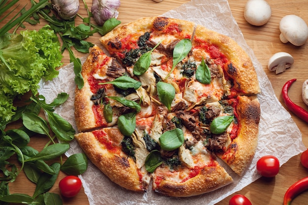 Deliciosa pizza com alcachofras e atum servida em mesa de madeira