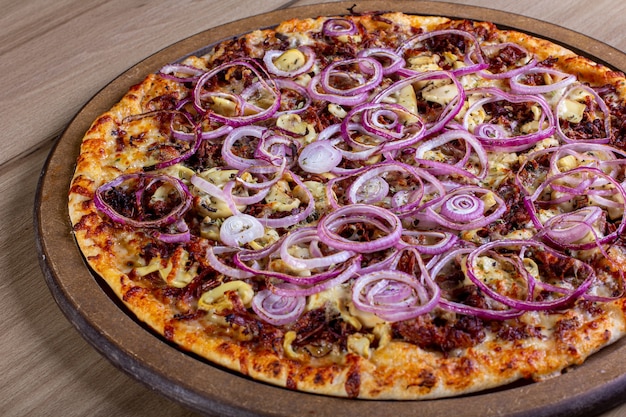 Deliciosa pizza com muito recheio sobre uma mesa de madeira