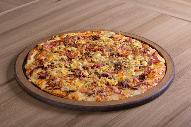 Deliciosa pizza com muito recheio sobre uma mesa de madeira