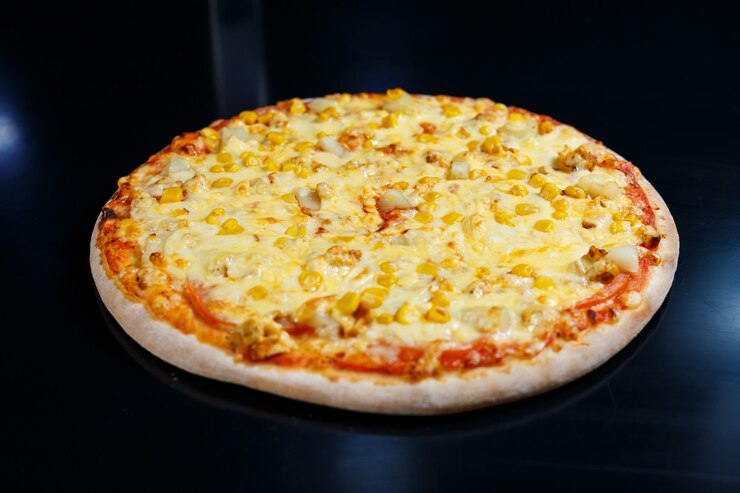 Deliciosa pizza italiana com carne crua, tomate e azeite em uma mesa de concreto escura. Vista superior com espaço de cópia.