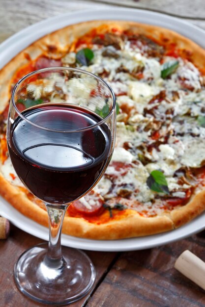 Deliciosa pizza italiana com taça de vinho tinto