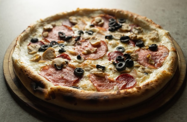 Deliciosa pizza italiana con primer plano de salchicha y mozzarella sobre un fondo gris. Pasteles preparados en una pizzería.