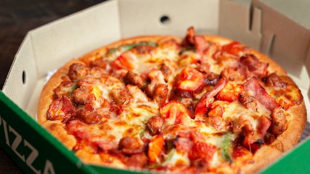 Deliciosa pizza italiana en rodajas con tocino, queso, tomate, pimiento en placa de madera