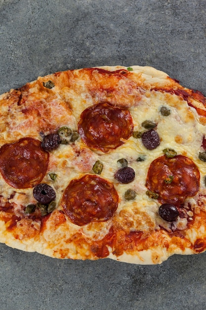 Foto deliciosa pizza italiana servida sobre fondo gris
