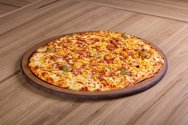 Deliciosa pizza con mucho relleno en una mesa de madera