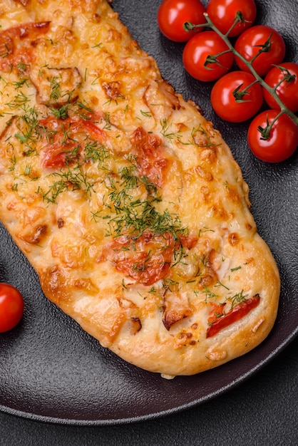 Deliciosa pizza de pan plano recién horneado con queso, tomate, salchicha, sal y especias