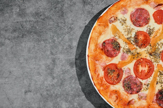 Deliciosa pizza de pepperoni sobre un fondo de hormigón gris. Vista superior de la pizza de pepperoni recién hecha caliente. Diseño con espacio para copiar texto. Idea de banner