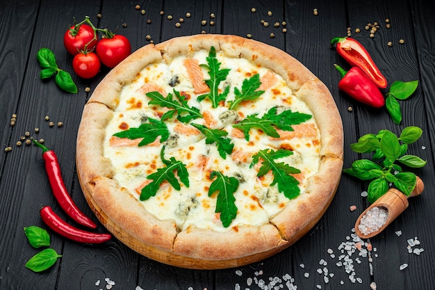 Deliciosa pizza quente com rúcula de salmão e especiarias diferentes na mesa de madeira pronta para comer