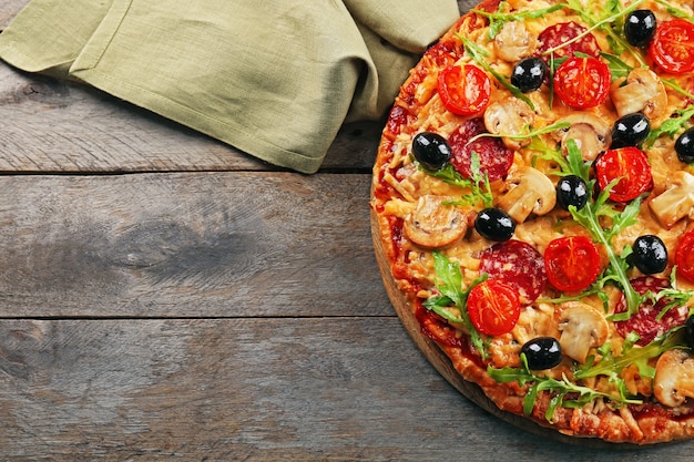 Deliciosa pizza saborosa com ingredientes na mesa de madeira