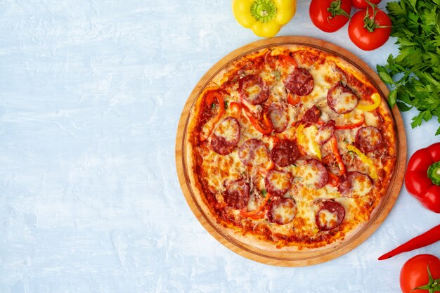 Deliciosa pizza con salchichas en la vista superior de fondo gris