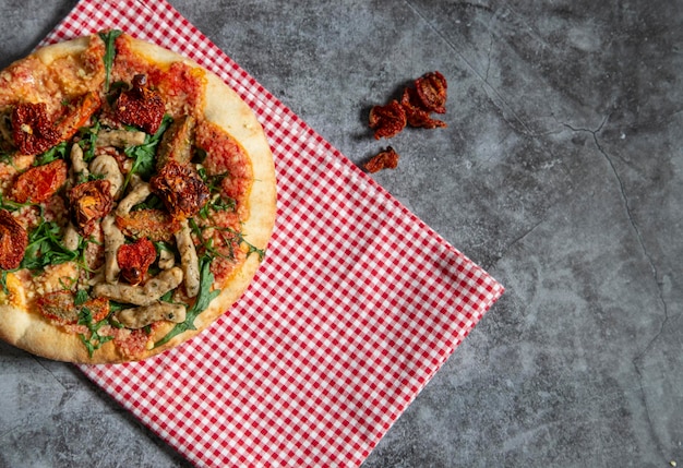 Deliciosa pizza vegana con tofu, tomates secos y rúcula con espacio para copiar texto