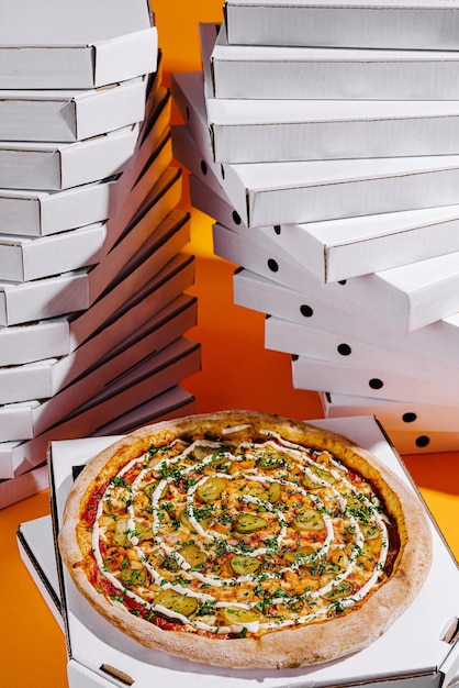 Deliciosa pizza con verduras y hierbas colocadas frente a pilas de cajas de pizza en un entorno vibrante