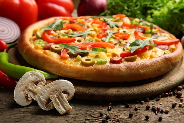 Deliciosa pizza con verduras sobre fondo de madera