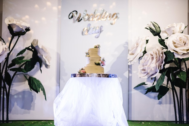 Deliciosa recepção de casamento Bolo em uma decoração de festa de fundo Copiar espaço Conceito de celebração Bolo na moda Parede de arco de casamento com flores de papel Decorações de casamento feitas à mão