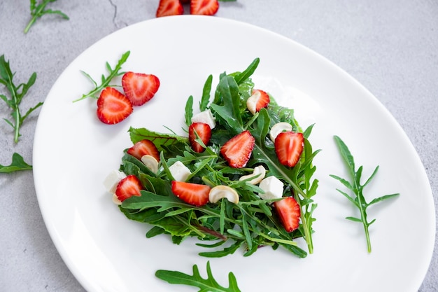 Deliciosa salada de morango com mistura de ervas rúcula espinafre folhas de queijo feta e castanha de caju