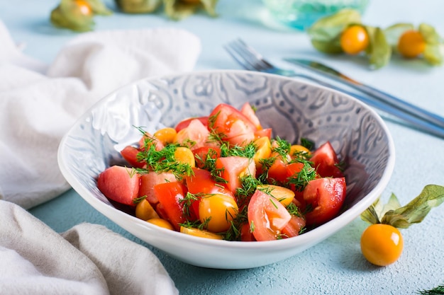 Deliciosa salada de tomate physalis e endro em uma tigela Comida vegetariana