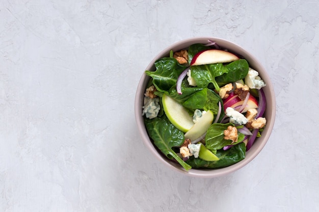 Deliciosa salada dietética com espinafre, maçã, cebola roxa, queijo azul, nozes