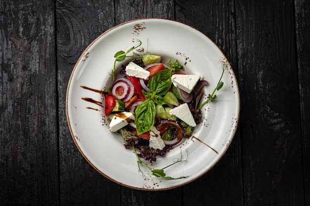 Deliciosa salada em um prato em uma mesa escura