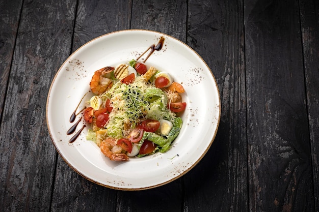 deliciosa salada em um prato em uma mesa escura