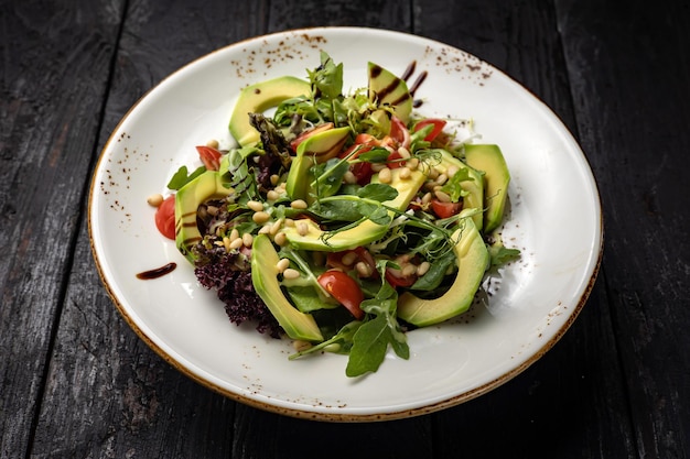 deliciosa salada em um prato em uma mesa escura