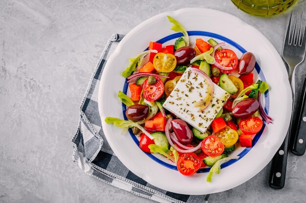 Deliciosa salada grega com queijo feta azeitonas tomates pepinos páprica e cebola roxa Vista superior