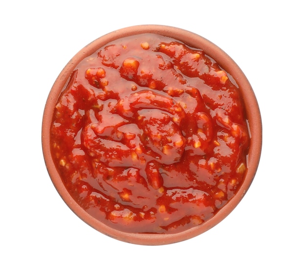 Deliciosa salsa adjika en un tazón aislado en la vista superior blanca