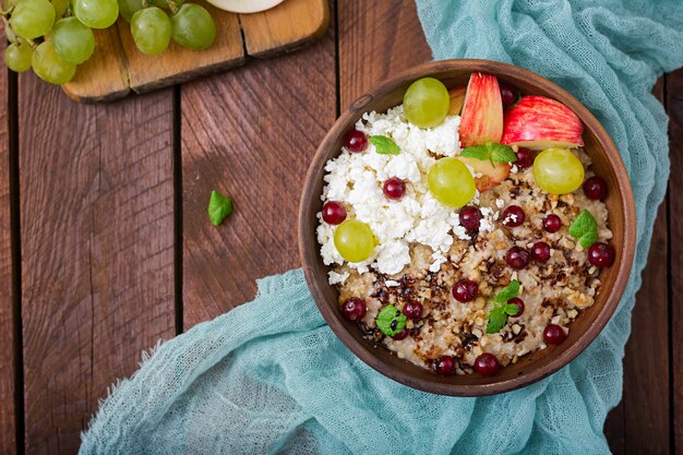 Deliciosa y saludable avena con uvas, nueces, manzanas y requesón. Desayuno saludable. Comida de fitness. Nutrición apropiada