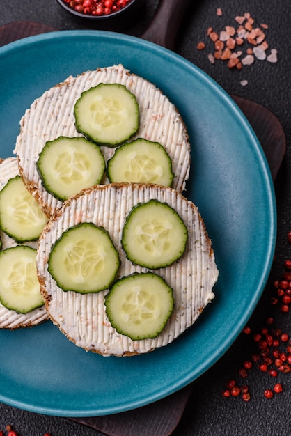 Deliciosa sanduíche vegetariana com torrada grelhada creme de queijo pepinos e sementes