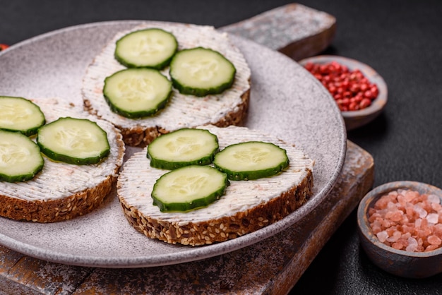 Deliciosa sanduíche vegetariana com torrada grelhada creme de queijo pepinos e sementes