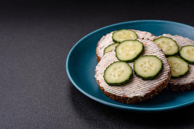 Deliciosa sanduíche vegetariana com torrada grelhada creme de queijo pepinos e sementes