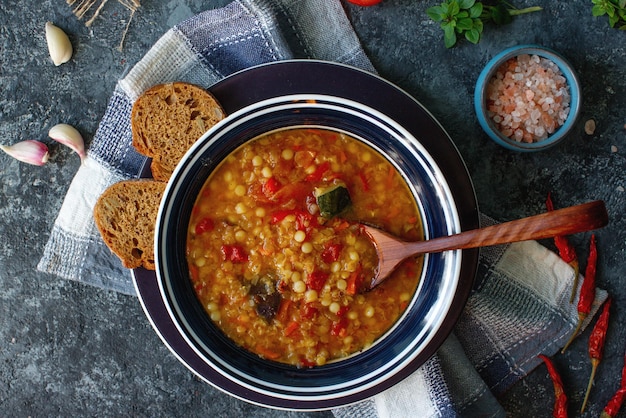 Deliciosa sopa casera de verduras de lentejas rojas orgánicas albahaca ajo y trozo de pan negro