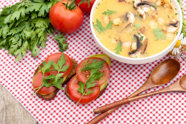 Deliciosa sopa de champiñones con bocadillos y tomates.