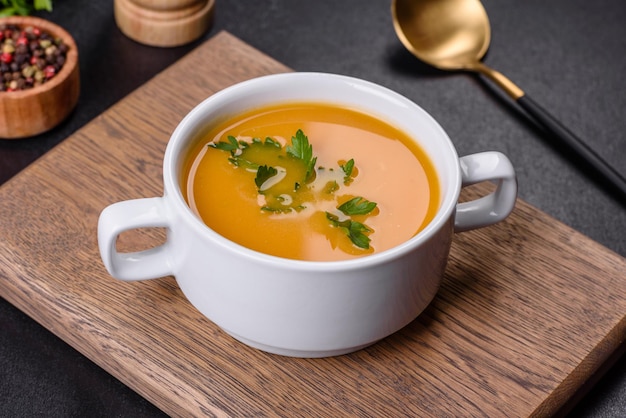 Deliciosa sopa de puré de calabaza fresca decorada con perejil en un plato blanco