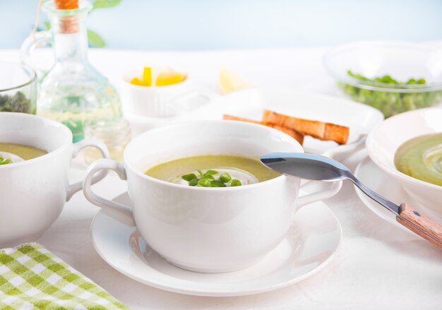 Deliciosa sopa de verduras con patatas, brócoli, guisantes y espinacas en la mesa.