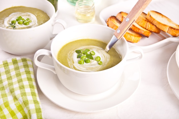 Deliciosa sopa de verduras con patatas, brócoli, guisantes y espinacas en la mesa.