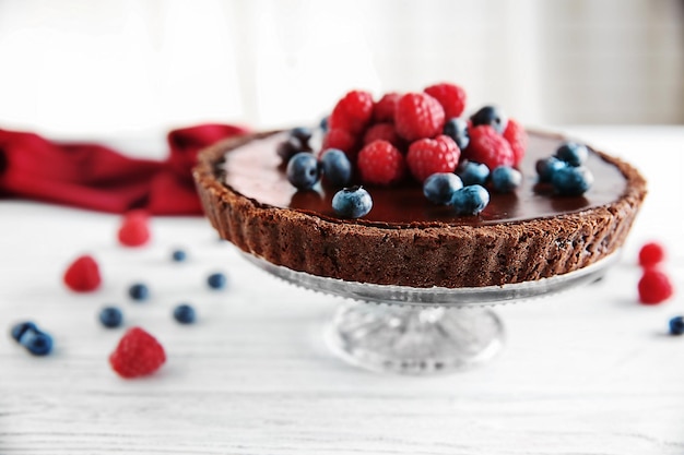 Deliciosa tarta de chocolate con bayas en mesa blanca