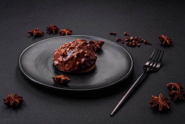 Deliciosa tarta de chocolate con nueces en un plato de cerámica negra sobre un fondo de hormigón oscuro