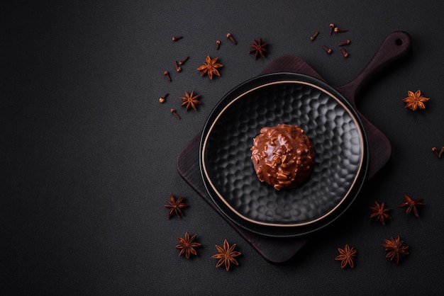 Deliciosa tarta de chocolate con nueces en un plato de cerámica negra sobre un fondo de hormigón oscuro