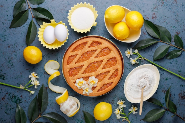 Deliciosa tarta de limón con limones frescos en concreto, vista superior