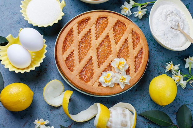 Deliciosa tarta de limón con limones frescos en concreto, vista superior