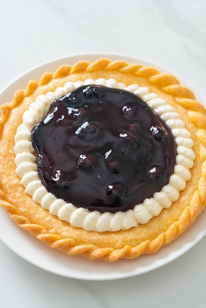 Deliciosa tarta de queso con arándanos en la placa blanca.